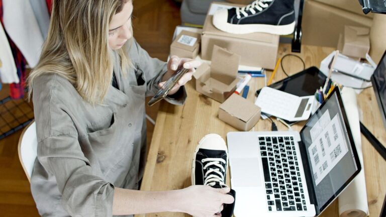 Versandvorbereitung im Onlinehandel: Pakete und Laptop am Packtisch